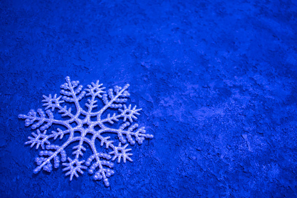Sfondo natalizio. Grande fiocco di neve d'argento su sfondo blu. Ricevuto. Design minimalista
. - Foto, immagini