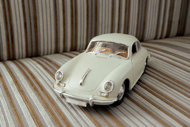 auto vintage model speelgoed op gestreepte sofa cover  - Foto, afbeelding