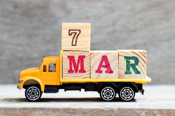 Грузовик держать букву блока в слово 7мар на деревянном фоне (Концепция на дату 7 месяцев Март
) - Фото, изображение