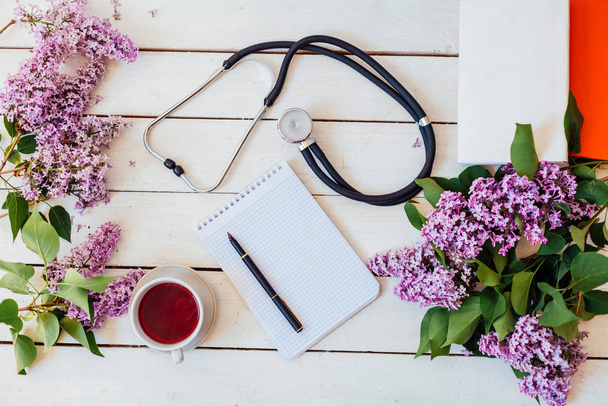 on the table lay a lilac, stethoscope, notebook - Foto, Imagem