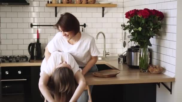 A young couple of lesbians gently cuddle at home. - Video
