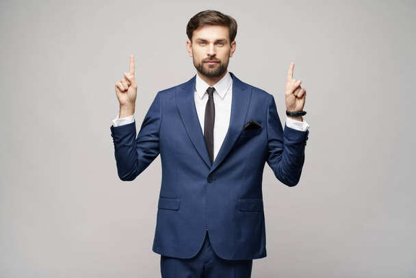 Portrait of a young businessman pointing on a copyspace with his finger - 写真・画像