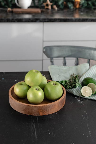 Green apples lie in a wooden plate - Foto, Bild