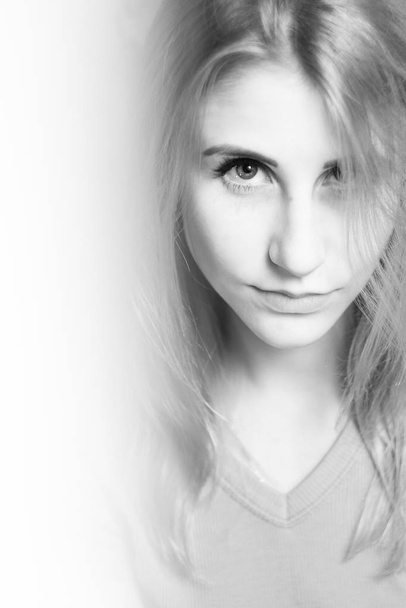 Ασπρόμαυρο πορτραίτο μιας νεαρής όμορφης γυναίκας που κοιτάζει stra - Φωτογραφία, εικόνα