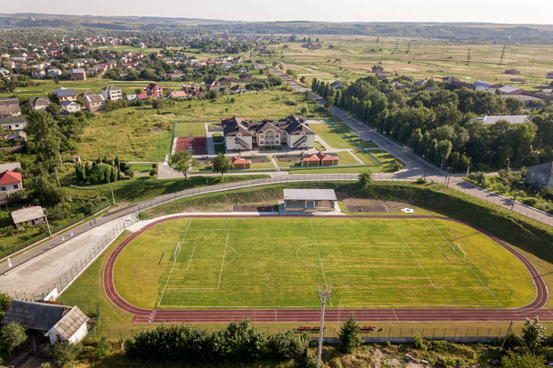 Vista aérea de un campo de fútbol en un estadio cubierto de verde
  - Foto, Imagen