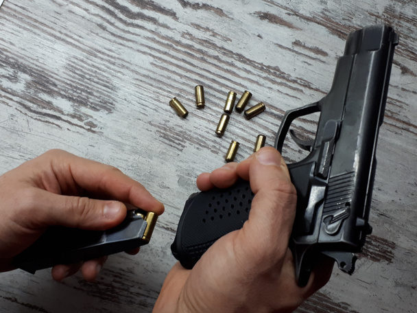close-up wapens, een zwart traumatisch pistool dat rubberkogels afvuurt in de hand van een man / vrouw - Foto, afbeelding