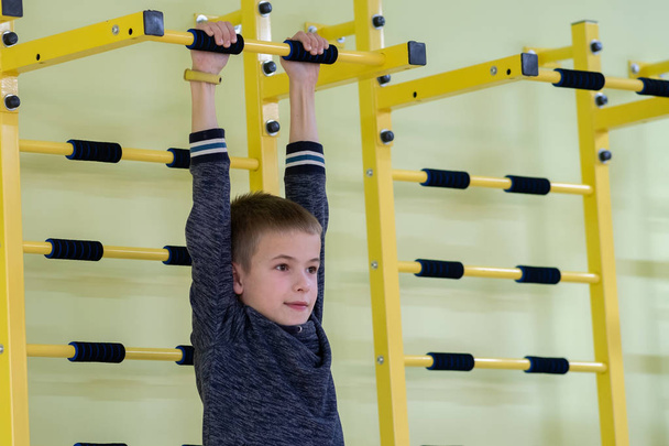 Giovane bambino ragazzo esercizio su un muro scala bar all'interno dello sport gy
 - Foto, immagini