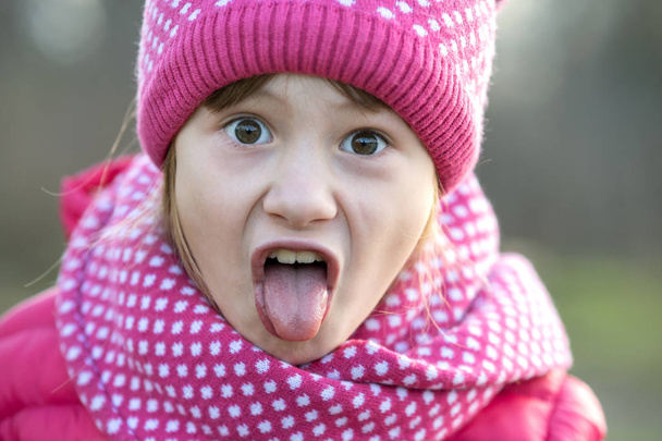 Hezké dítě dívka v teplé pletené zimní oblečení venku. - Fotografie, Obrázek