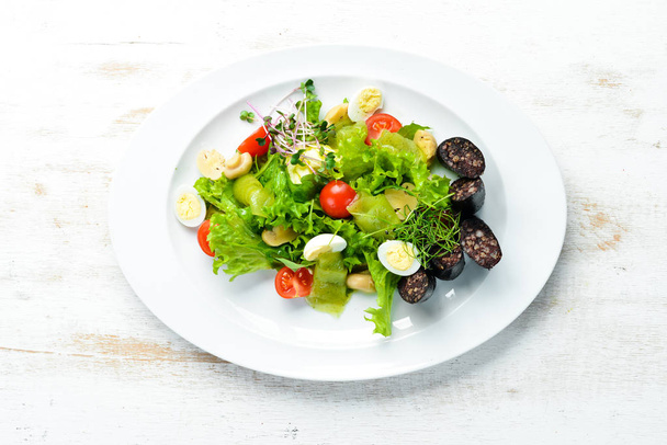 Salad of vegetables, blood sausage and mushrooms on a plate. Top view. free space for your text. Rustic style. - Foto, Bild