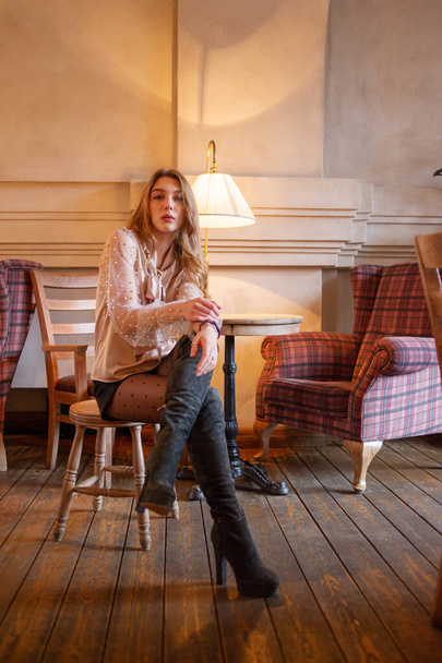 young pretty woman in cafe. grunge. Girl in a cafe in a beige blouse - Foto, immagini
