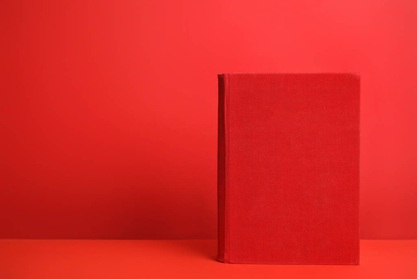 Hardcover book on red background. Space for design - Фото, изображение