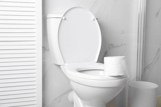New paper roll on toilet bowl in bathroom - Fotó, kép
