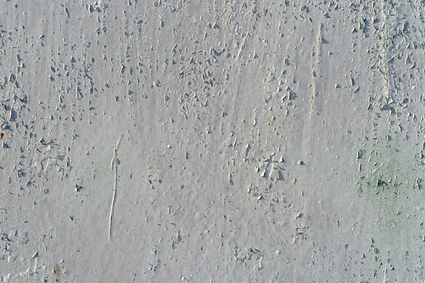 Starý kovově bílý lakovaný povrch s oloupanou barvou, škrábanci a prasklinami v jasném slunečním světle. Je vidět několik světle zelených skvrn. Abstraktní bílá - zelená textura pozadí - Fotografie, Obrázek