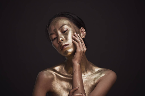 Beautiful young asian woman with bronze paint - Foto, Imagen