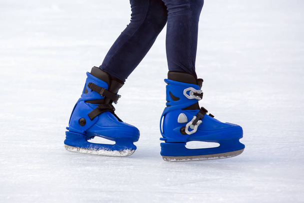 Piernas de un hombre patinando en una pista de hielo. Pasatiempos y deportes. Vacati.
 - Foto, Imagen
