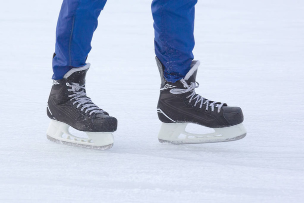 legs of a skating man on an ice rink. Hobbies and sports. Vacati - Photo, Image