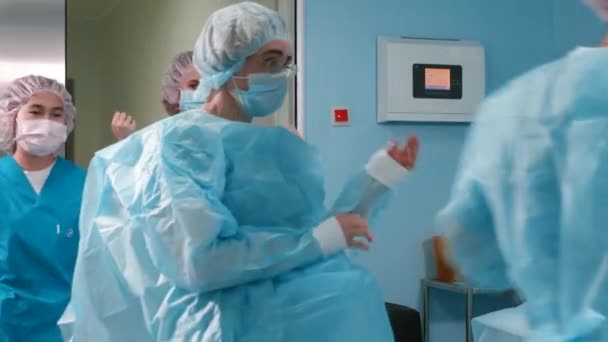 Enfermera y asistente bata de cirujano en la sala de cirugía
 - Metraje, vídeo