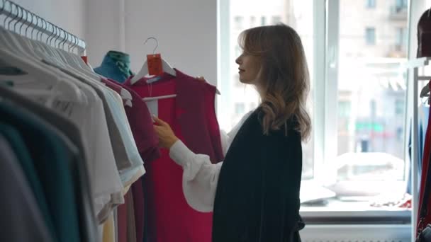 Fiatal női ruhák kiválasztása az üzletben. - Felvétel, videó