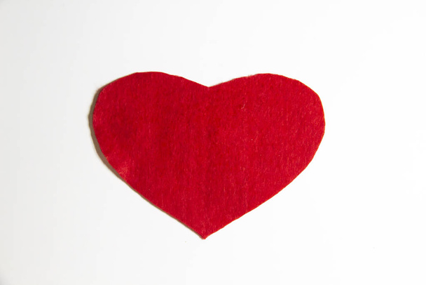 Herz aus Filz auf weißem Hintergrund. ein rotes Herz aus Filz - Foto, Bild