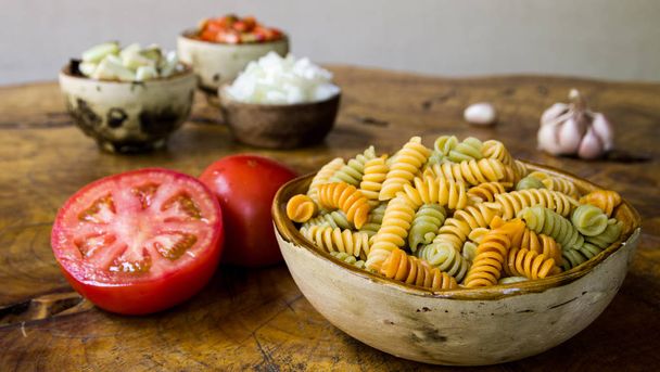 Verse ingrediënten voor het koken: pasta, tomaat, rode peper, ui, aubergine en knoflook - Foto, afbeelding