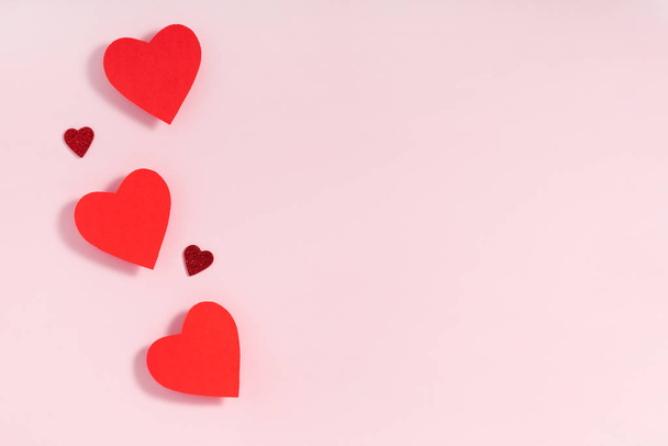 Valentijnsdag frame compositie. Rode harten op pastelroze achtergrond. Bovenaanzicht, flat lay, kopieerruimte - Foto, afbeelding