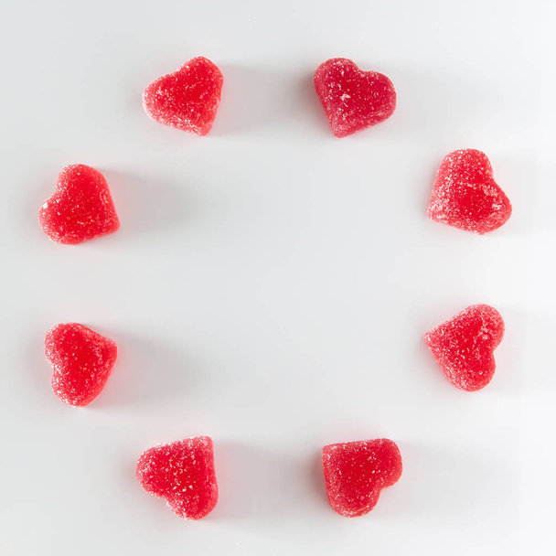 The circular arrangement of sweet red fruit jelly in the shape of a heart. Symbol of the day of lovers. Place for your text. - Photo, Image