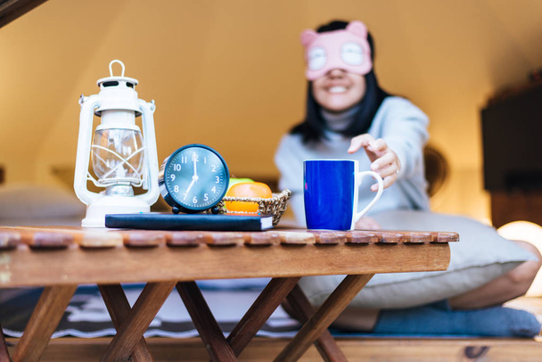 Onnellinen aasialainen nainen tavoittaa ja juo kuumaa kahvia aamulla, Onnellinen ja hymyilevä, Rentouttava aika
 - Valokuva, kuva