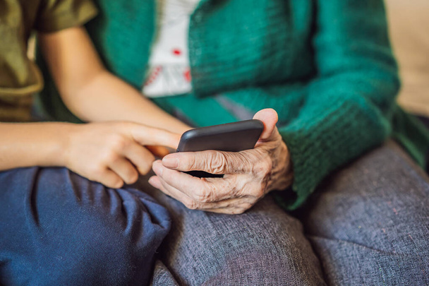 La abuela y el nieto están mirando un teléfono inteligente
 - Foto, Imagen