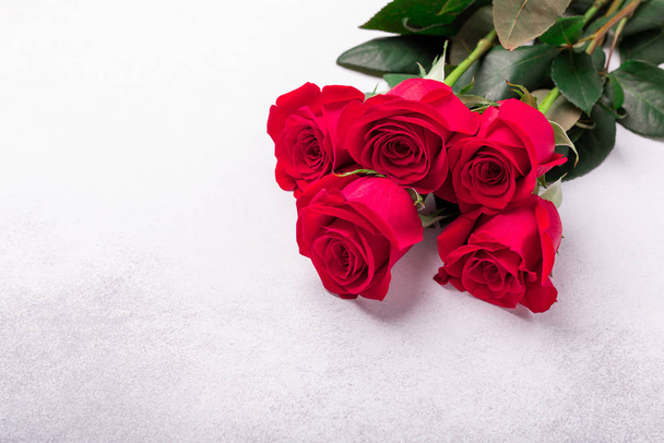 Red roses flowers on stone background. Valentine's greeting card. Top view. Copy space - Foto, imagen