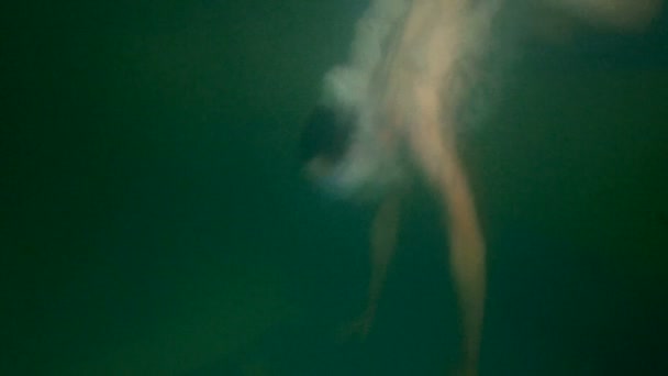 Agua turbia. El adolescente enmascarado bucea y nada bajo el agua en la piscina. Burbujas de aire alrededor del cuerpo. El tipo de los bañadores
. - Metraje, vídeo