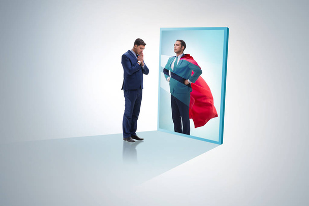 Zakenman die zichzelf in de spiegel ziet als superheld - Foto, afbeelding