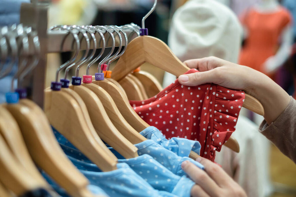 Une femme choisit de nouveaux vêtements, faisant du shopping dans un centre commercial de mode, gros plan des mains
 - Photo, image
