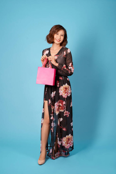 Carefree asian lady posing after shopping. Adorable woman holding store bags. - 写真・画像