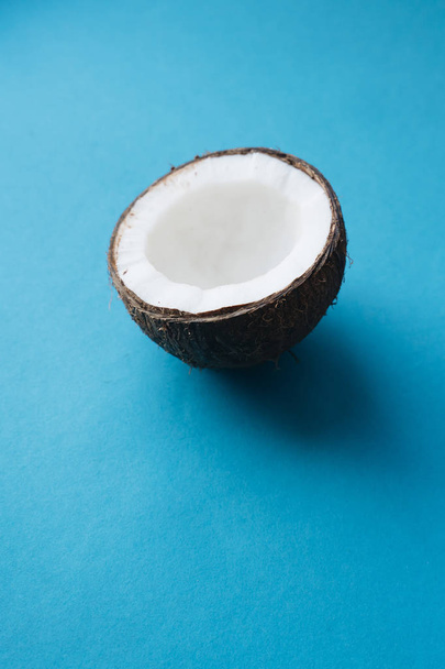 open coconut on blue background, copy space  - 写真・画像