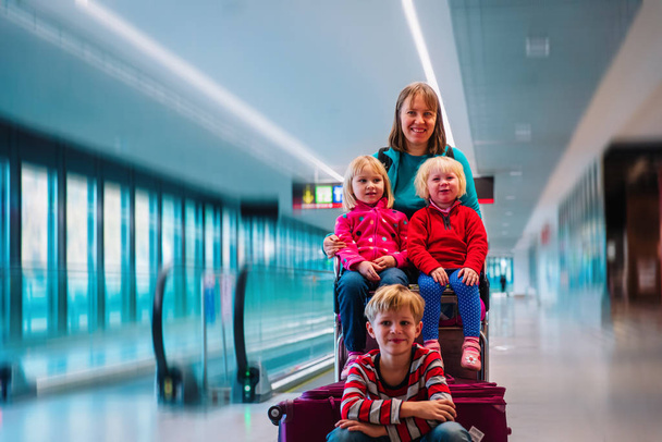 mother with three kids travel in the airport, family travel - Photo, Image