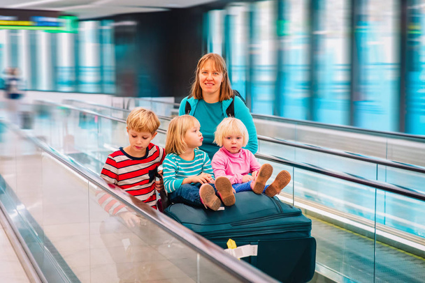 mother with three kids travel in the airport, family travel - 写真・画像