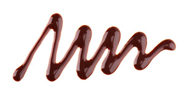 Schokoladensirup tröpfelt isoliert auf weißem Hintergrund. Spritzer süße Schokoladensoße. Ansicht von oben. - Foto, Bild