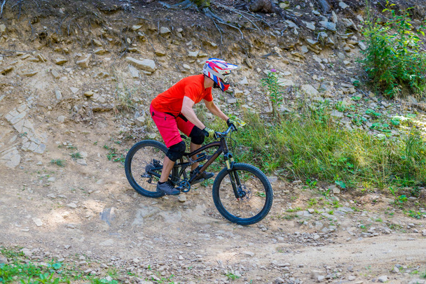 Professional Cyclist Riding the Bike on the Rocky Trail. - Photo, image