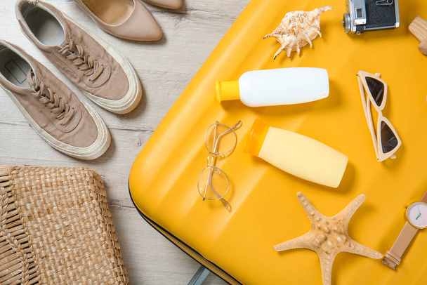 Suitcase and travel accessories with shoes on floor - Photo, Image
