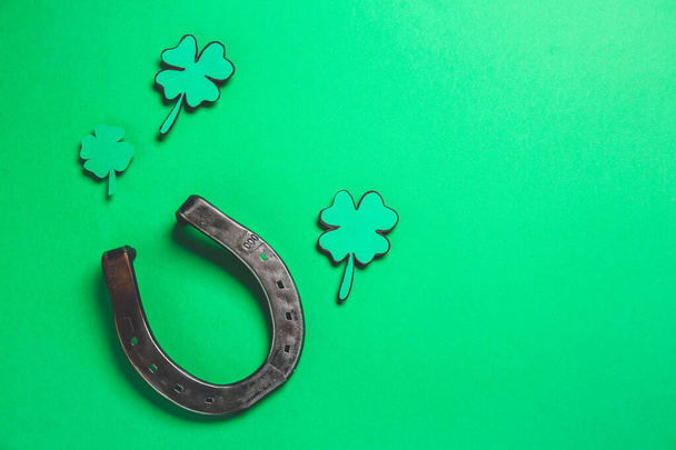 Horseshoe and shamrock on green background. St. Patrick's Day celebration - Photo, Image