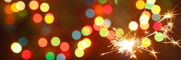 beautiful sparklers on the background of a garland. beautiful banner for the New Year. - Photo, Image