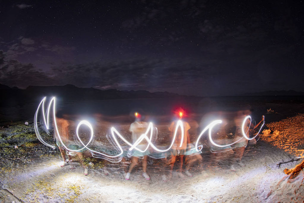 Mexico glow light painting writing on the beach - Photo, Image
