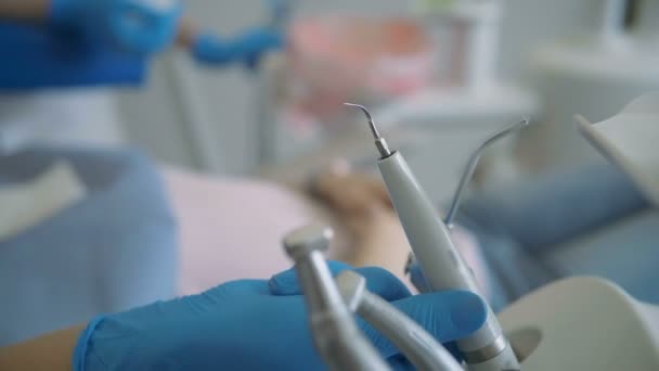 vista de cerca de los instrumentos dentales mujer que visita la clínica acostada en la silla dental médico comprobar sus dientes
 - Metraje, vídeo