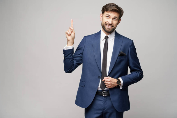 Portrait of a young businessman pointing on a copyspace with his finger - Foto, Bild