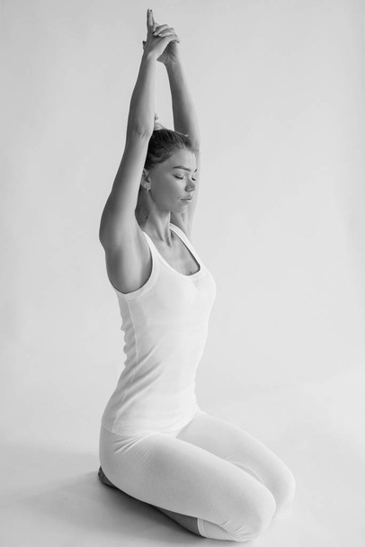 monochroom portret van Kaukasisch blond mooie vrolijke vrouw doen yoga asanas. Gezond leefstijl- en sportconcept - Foto, afbeelding