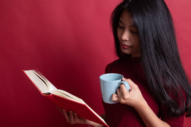 Young Asian woman with a book and cup of coffee. - Φωτογραφία, εικόνα