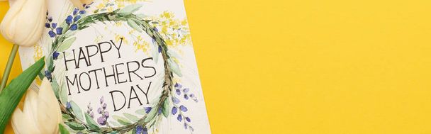вид сверху на весенние тюльпаны и поздравительную открытку на красочном желтом фоне, панорамный снимок
 - Фото, изображение
