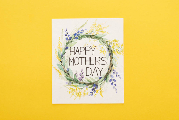 bovenaanzicht van gelukkige moeders dag wenskaart op kleurrijke gele achtergrond - Foto, afbeelding