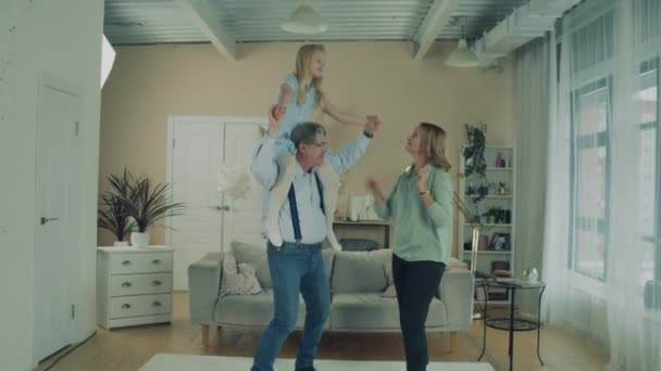 Grandma and granddad are dancing with granddaughter - Filmati, video