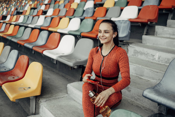 Portrait of One Sports Fitness Girl Dressed Fashion Sportswear Outfit Doing Exercise and Training at the City Stadium, Healthy Lifestyle Concept - 写真・画像